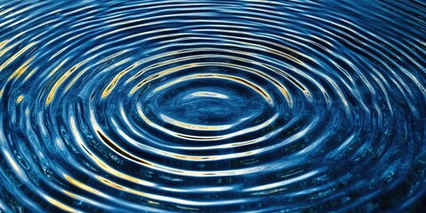 Close-up of concentric ripples on blue water with yellow light reflection.