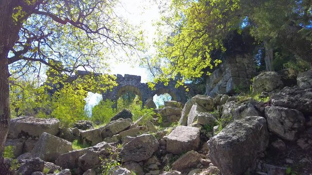 4K Ancient stone arches of Termessos - Gulluk Mountain Termessos NP near Antalya, Turkey. Perfect for themes of ancient ruins, lost cities, historic travel, and natural beauty blending with archaeolog