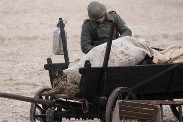 HORSE DRAWN WAGON - An old World War II refugee vehicle on the sea beach and wehrmacht soldier 