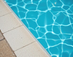 Obraz premium close up view of light blue and white tiles beside a turquoise swimming pool, creating a fresh and relaxing backdrop.