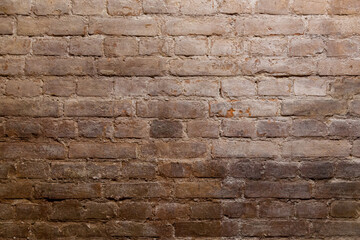 Rough brown brick wall with visible mortar lines and subtle signs of age, ideal for background or architectural detail use