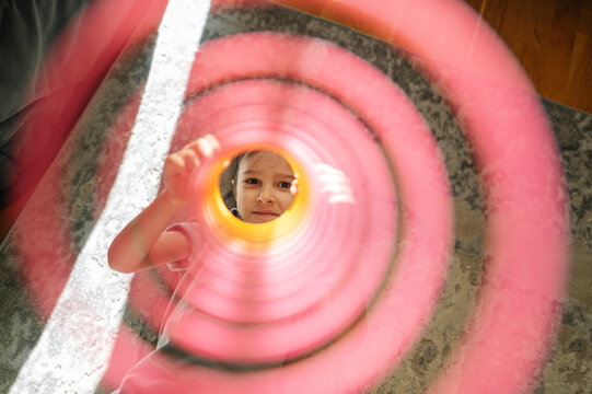 Boy playing with a colorful spring toy at home