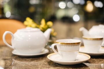 Fine bone china teacups with gold trim and two pots of tea: Taiwanese tie guan yin oolong and Japanese sencha, at the lounge of Montien Surawong, a hotel in Silom - Bang Rak, Bangkok, Thailand
