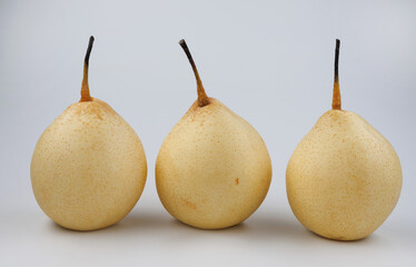 Three pears in a row on a white background. Snow pear.