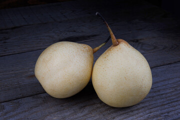 Two ripe juicy pears on a wooden background. Snow pear.