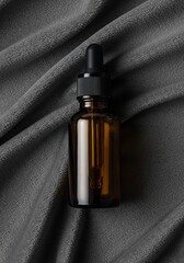 Amber glass dropper bottle on gray fabric