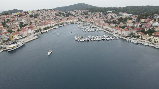 Aerial view of Mali Losinj town on Losinj island, Croatia, Europe. Drone video capturing Mali Losinj town center, harbor, boats and bay of Adriatic Sea.