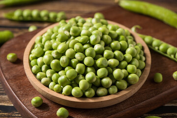 fresh green peas on wooden table.