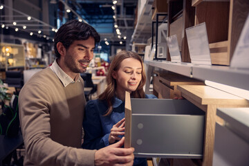 Couple explores various modern furniture options in stylish store highlighting unique designs