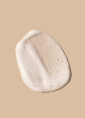 texture foam mousse foam cosmetic smear sample on beige background