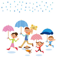 雨の日に傘をさして外出する仲良し家族