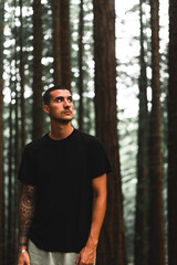 Chico joven en bosque de secuoyas, chico rapado con camiseta negra, Comillas, Cantabria