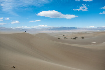 Gentle hills of the Mesquite Sand Dunes ripple under a blue sky, showcasing the soft terrain of the Pyramid Dunes in Death Valley, captured May 26, 2019