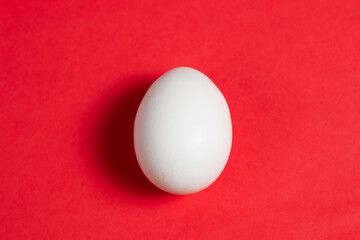 White egg on red background 