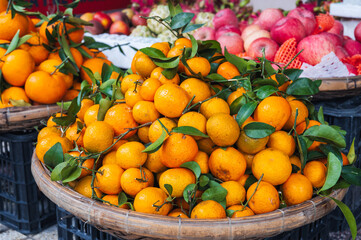 pile of fresh ripe sweet tangerines on counter at a grocery market in Asia