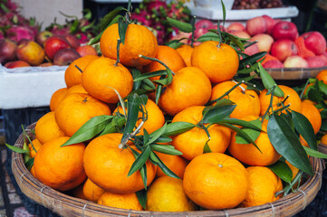 pile of fresh ripe sweet tangerines on counter at market in Asia close-up