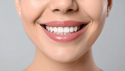 Fototapeta premium Smiling woman on light grey background, closeup, showcasing dental veneers for a bright and confident smile