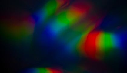 Obraz premium Blurred refraction light texture overlay effect. Dark Holographic rainbow background.