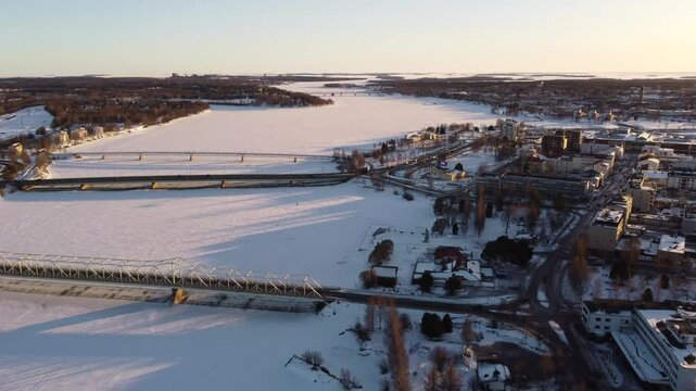 City of Tornio in winter on banks of frozen Torne River, Finland. Aerial backwards