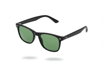 Black framed sunglasses with green lenses casting a shadow on a white background in a studio shot