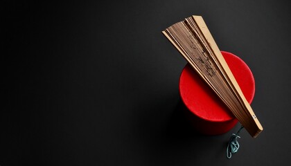Carved fan. Panda, bamboo symbols. An oriental style fan and a red box, isolated on black. Minimalist composition. Studio shot © Gintare Stackunaite