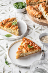 Greek pie spanakopita with feta cheese and spinach on a white plate on printed tile background
