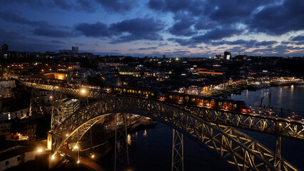 Obraz premium Sunset Luis I Bridge At Porto In Porto District Portugal. Sunset City Scene. Illuminated Bridge Landscape. Luis I Bridge At Porto District Portugal. Beautiful Dusk Skyline. 
