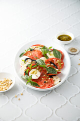 Traditional Caprese salad with pesto sauce