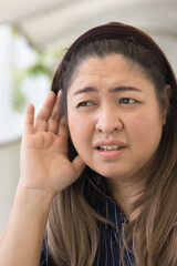 Southeast Asian Woman's Hearing Ear Captures the Essence of News, Fake or Real News, Hard of hearing or ear health issue Concept