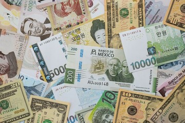 Big amount of money bills of different currencies and countries. Assortment background of international cash in big pile close up