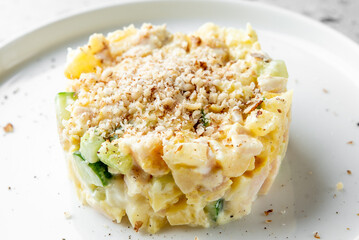 A close-up of a creamy chicken salad with diced vegetables, topped with grated nuts, served on a white plate. Fresh, healthy, and appetizing, ideal for culinary and food photography.