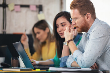 Young software developer in coworking open space working