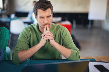 Young software developer in coworking open space using computer
