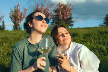 Beautiful girls drinking wine at sunset