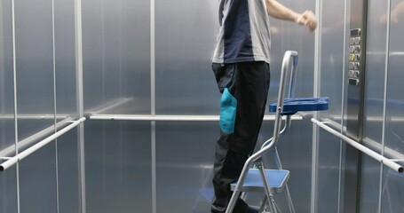 Elevator technician fixing the elevator - Powered by Adobe