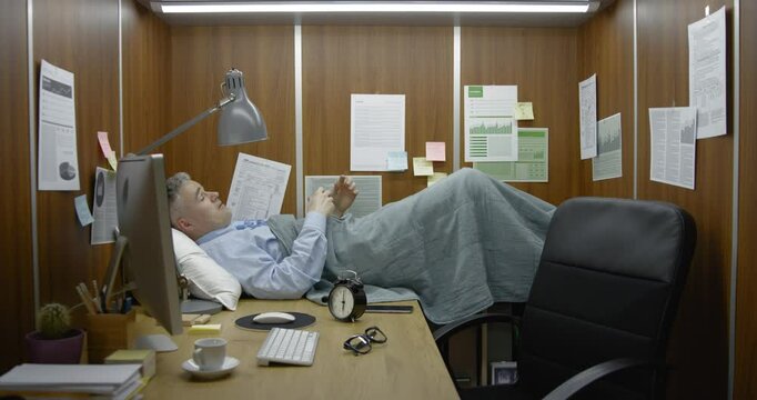 Businessman working and sleeping in his small office