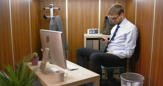 Bored employee sitting in his small office
