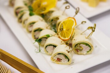 Savoring delightful chicken and vegetable rolls at a festive gathering in a cozy dining setting