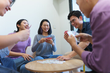 Friends enjoying a card game together in a cozy indoor setting during a weekend gathering