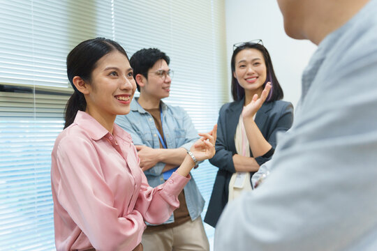 Engaging conversation among four young professionals in an office setting during daylight hours