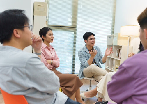 Discussion among young adults in a modern office setting during a collaborative meeting on innovative ideas and projects