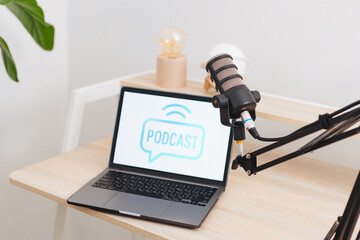 Podcast recording setup in modern office with laptop and microphone for educational interviews