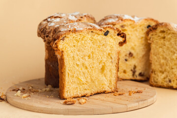 Panettone cake with raisins and candied fruit, sweet traditional Italian pastry on beige...