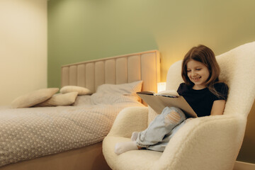 Fototapeta premium Young Girl Relaxing and Reading in a Comfortable Bedroom Setting