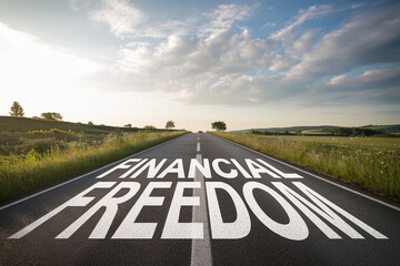 Asphalt road stretching to horizon, words "Financial Freedom" painted on surface, symbolizing journey toward financial independence and success