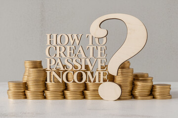 Stacks of gold coins with wooden letters spelling "How to create passive income" and a question mark, showcasing financial growth and passive income strategies