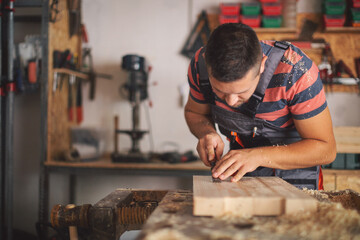 Young carpenter glueing wood