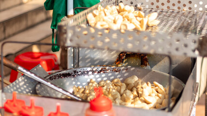 Deep fried meatballs or Bakso Goreng or Basreng are fried in a pan at a street vendor's cart.