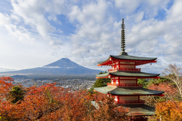 Chureito Pagoda stands amid vibrant autumn foliage with Mount Fuji in the background under a blue sky creating an iconic Japanese landscape in Fujiyoshida Yamanashi Japan © Artem