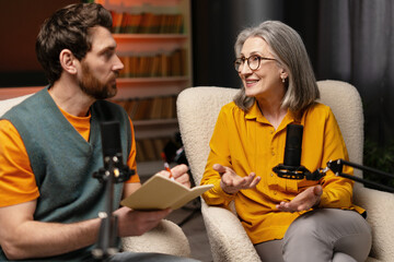 Radio host interviewing a senior woman in a podcast studio